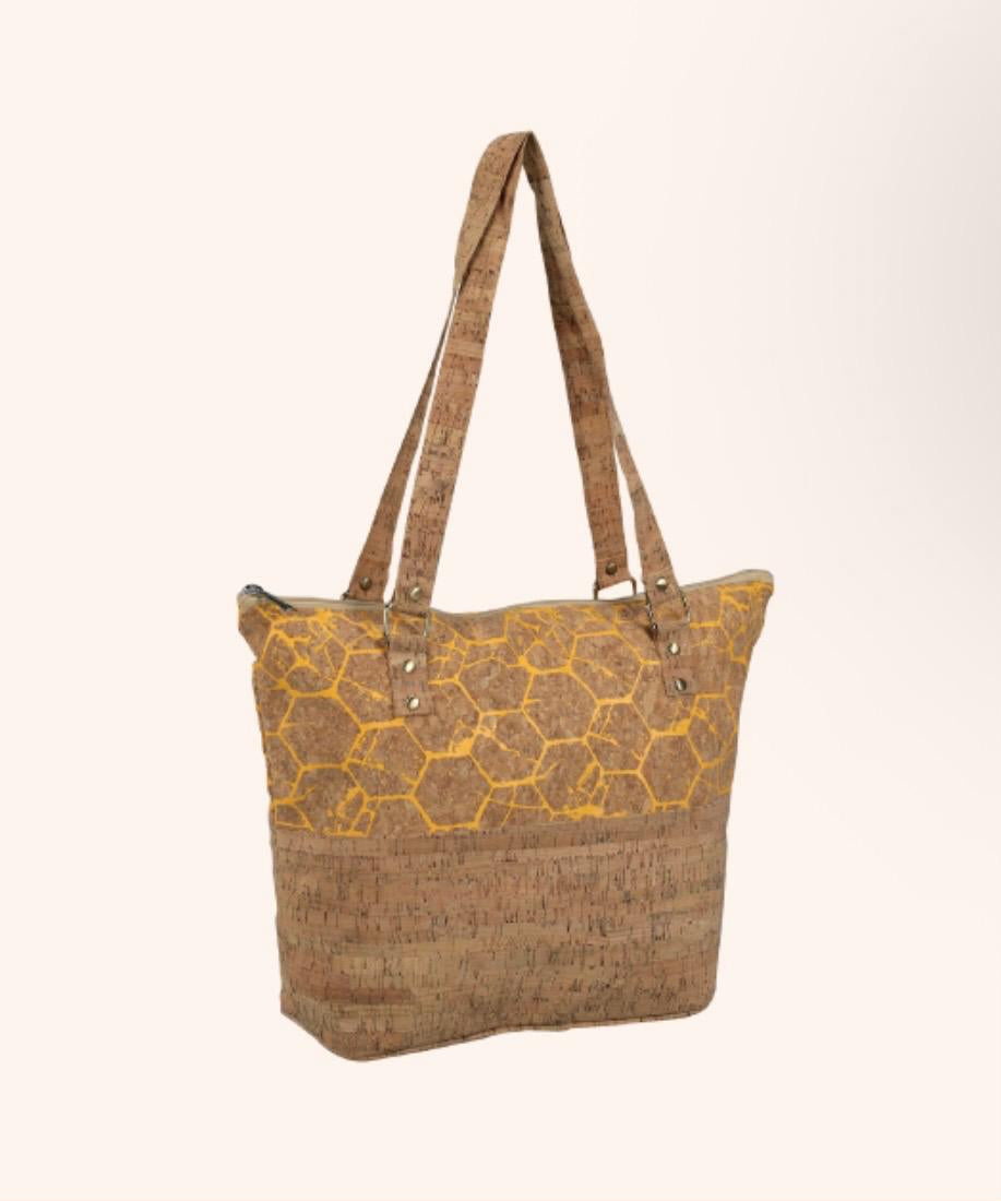 A cork tote bag with a yellow honeycomb pattern on the upper half and a solid cork textured lower half, featuring dual shoulder straps, shown against a light beige background.